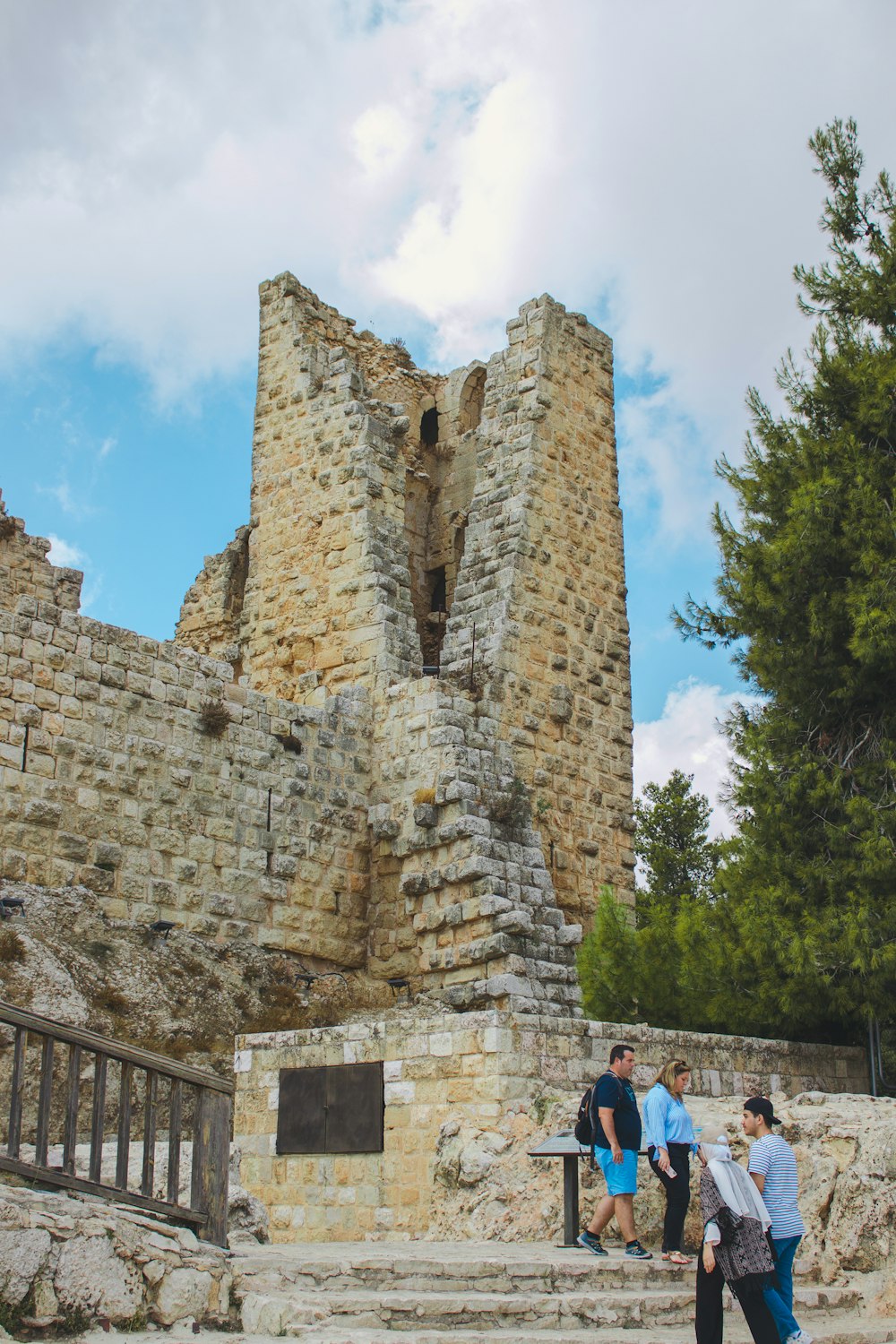 a group of people standing in front of a stone castle