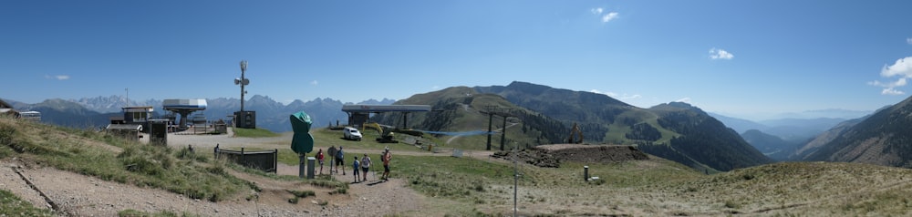 a group of people standing on top of a lush green hillside