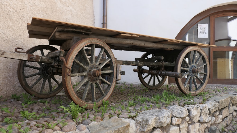 an old wooden cart sitting on top of a stone wall