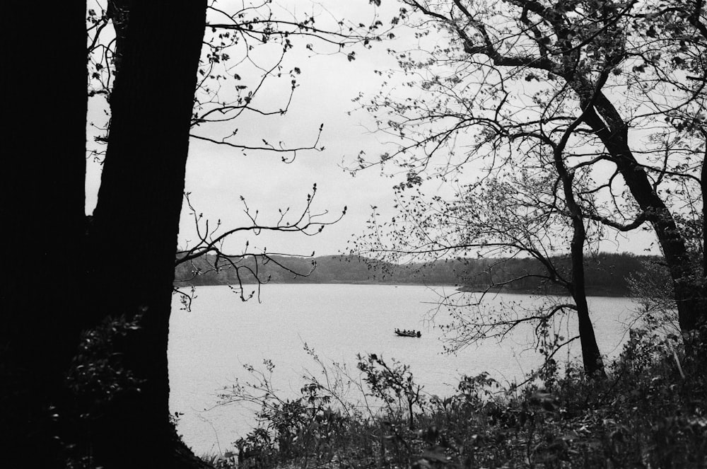 a black and white photo of a boat on a lake