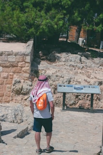 a man with a backpack standing in front of a sign