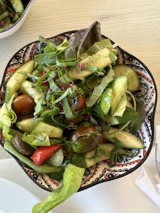 A colorful bowl filled with a fresh garden salad with cherry tomatoes, cucumbers, and mixed greens.