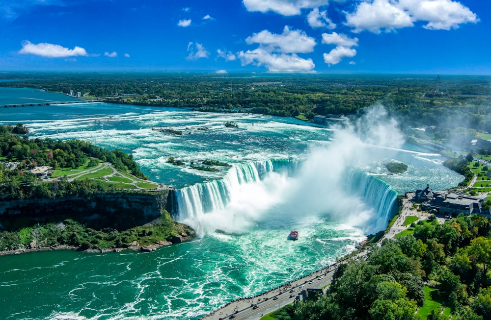 a large waterfall with a boat in the middle of it