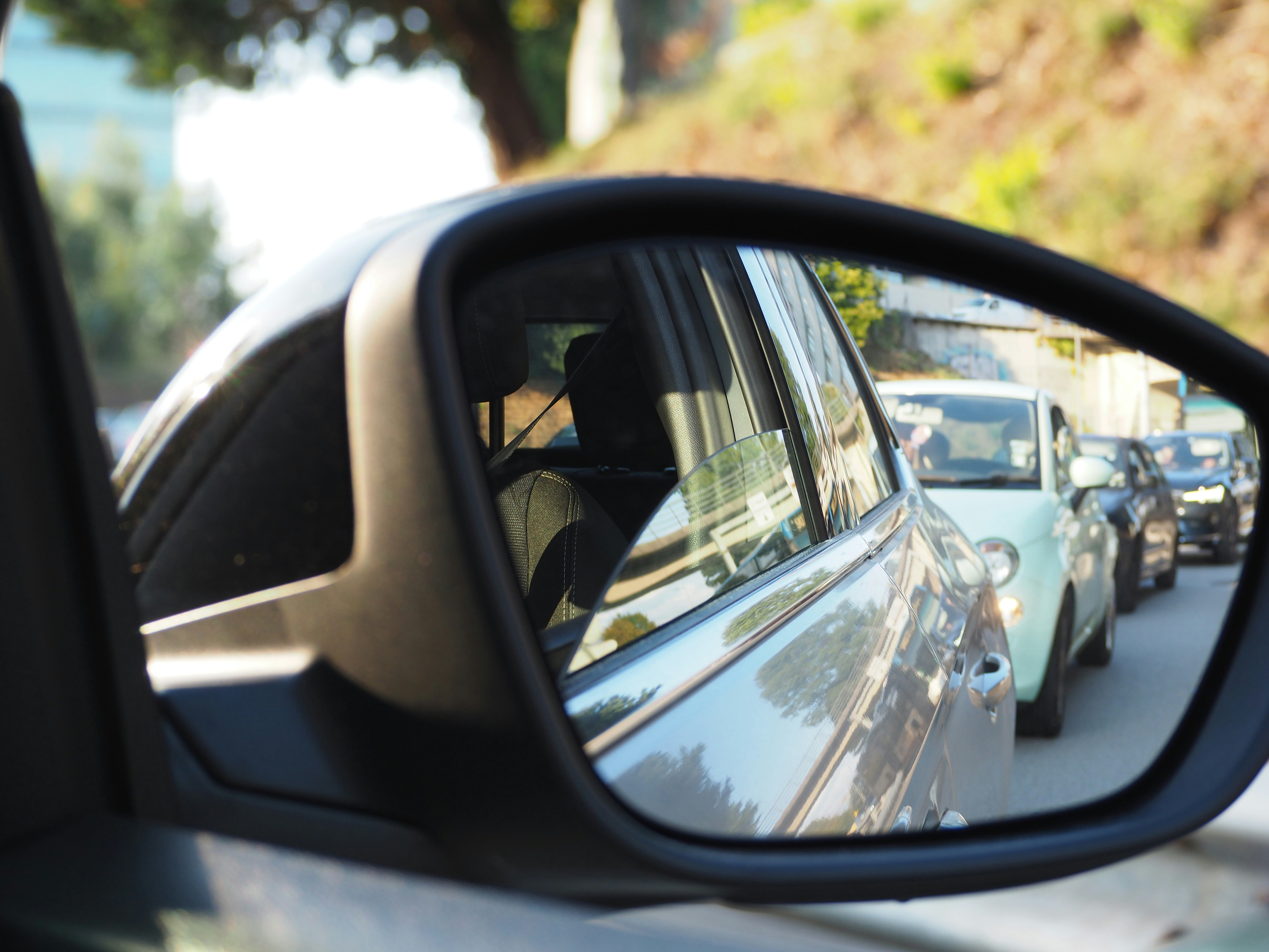 a rear view mirror on a car reflecting a line of cars