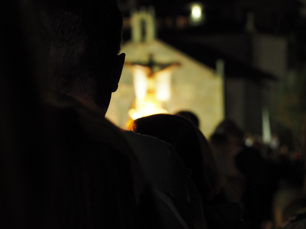 a crowd of people standing around a church at night