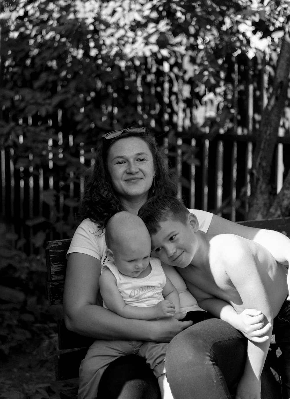 a woman sitting on a bench holding a baby