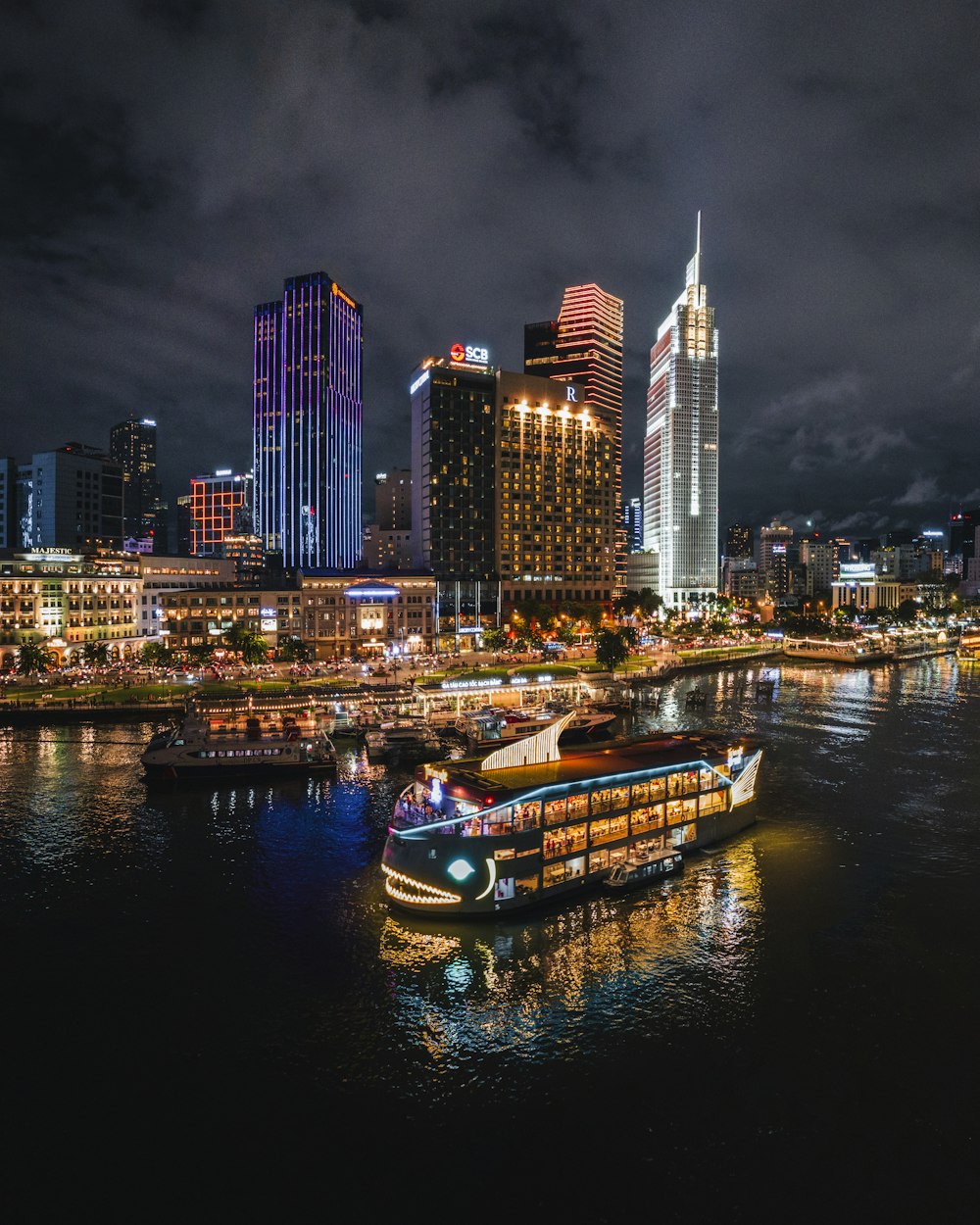 a boat floating on top of a river next to tall buildings