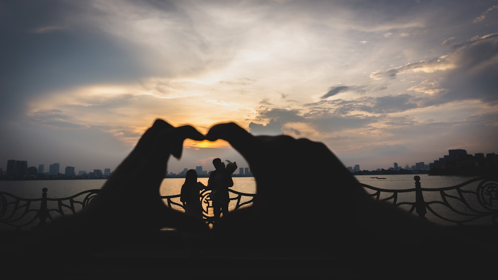 two people making a heart shape with their hands