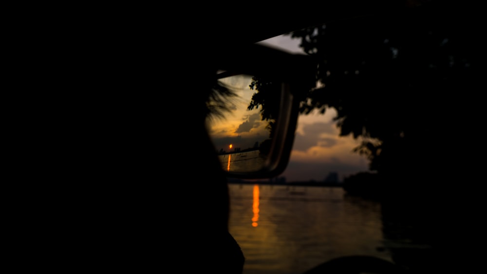 a view of a sunset through a car's side view mirror