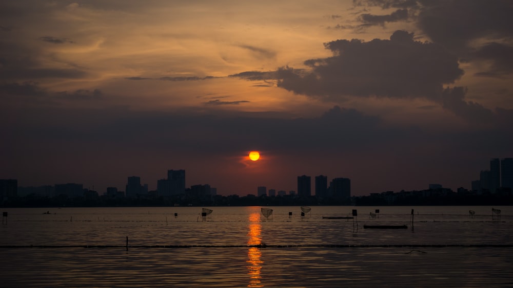 a large body of water with a sunset in the background