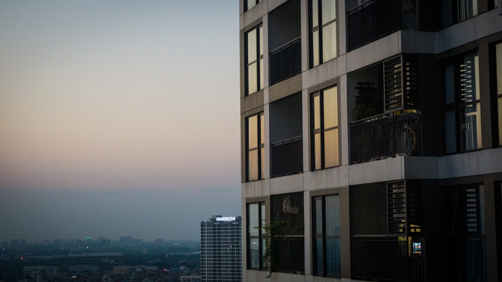 a tall building with lots of windows next to a city