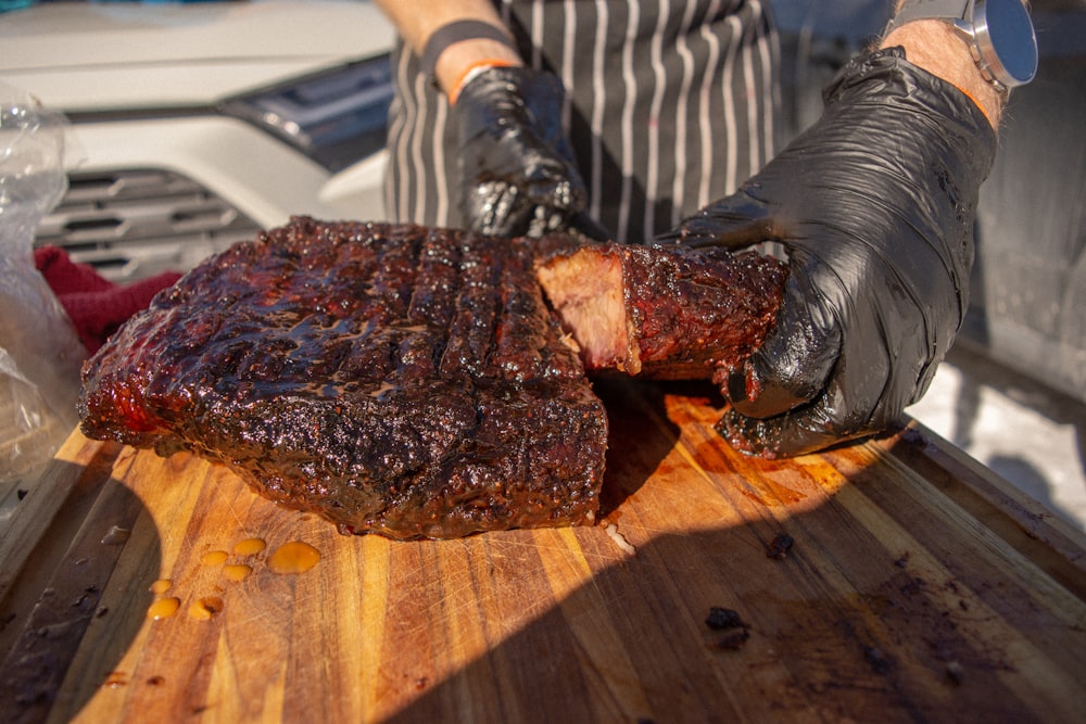 a person cutting up a piece of meat on a cutting board