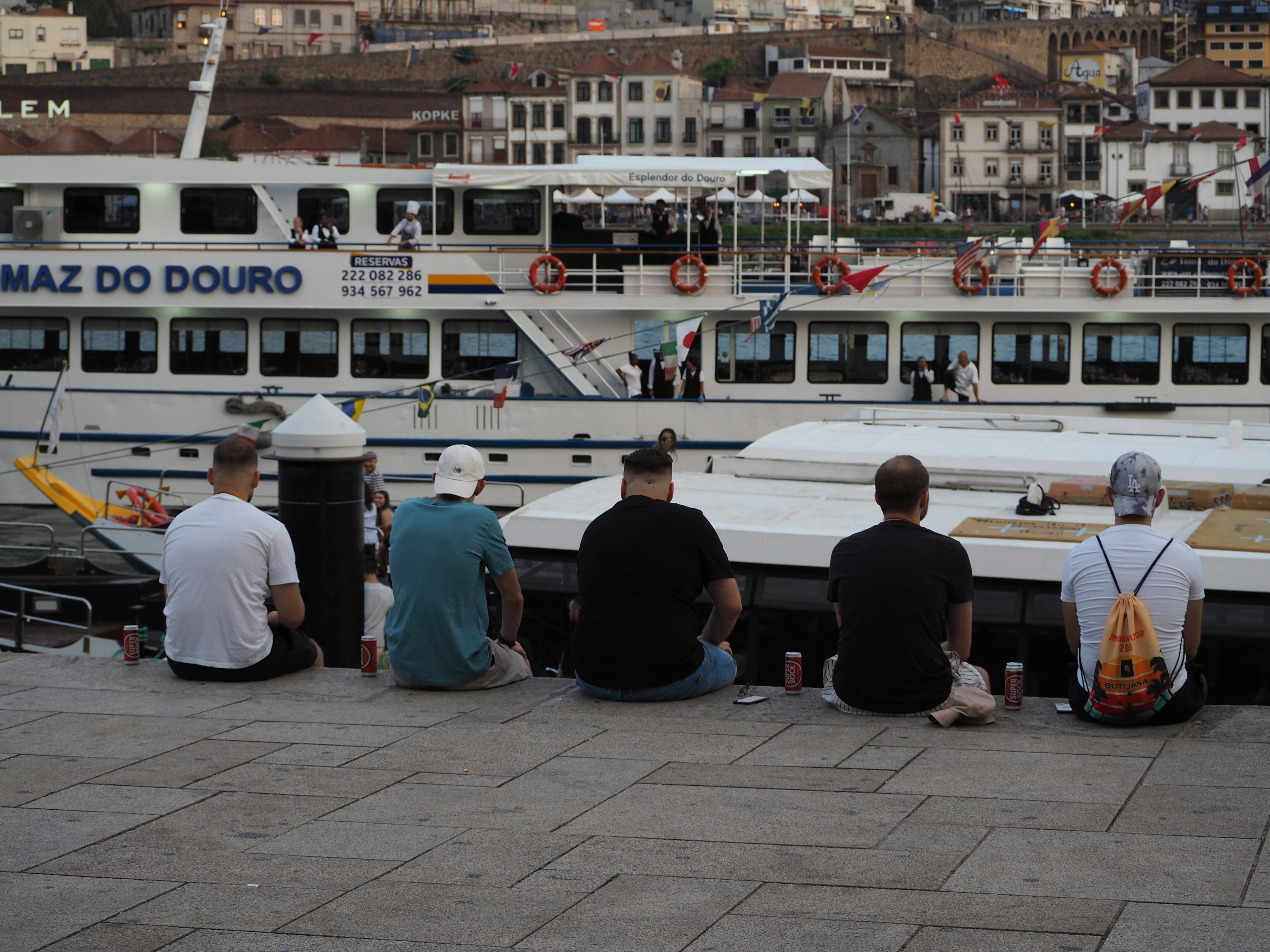 Un grupo de personas sentadas en un muelle junto a un barco