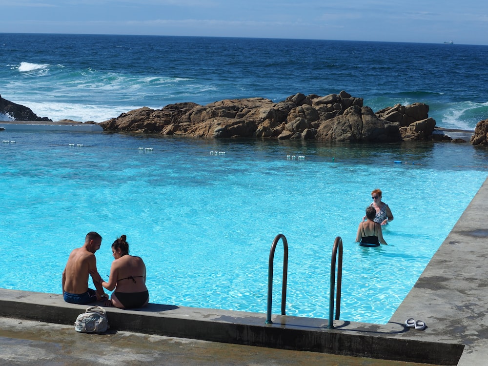 a couple of people that are sitting in a pool