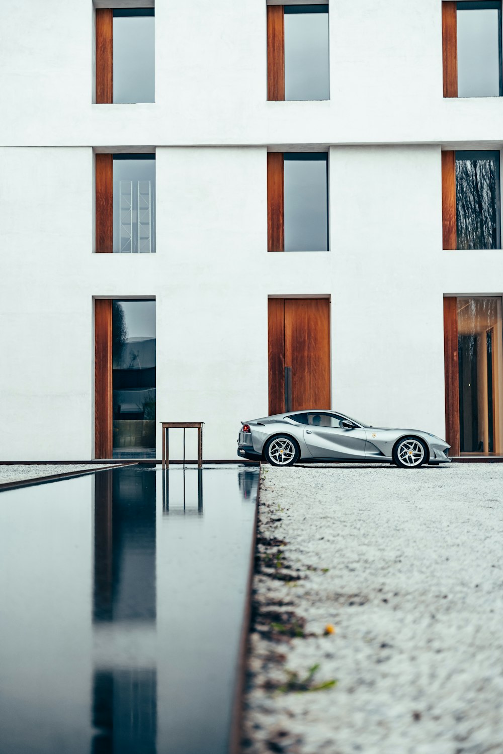 a silver car parked in front of a white building