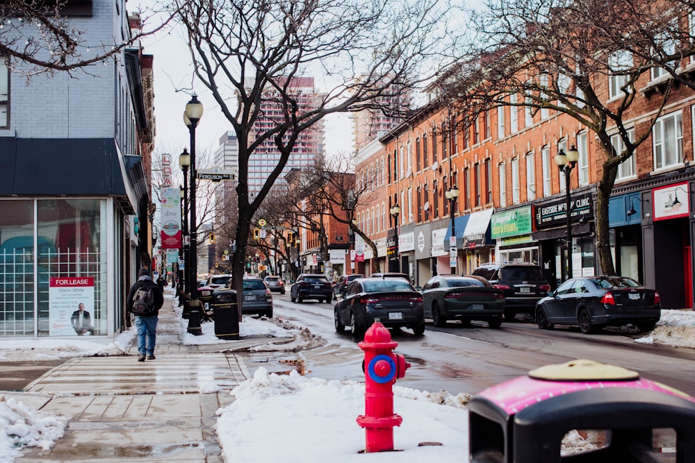 a red fire hydrant sitting on the side of a snow covered street