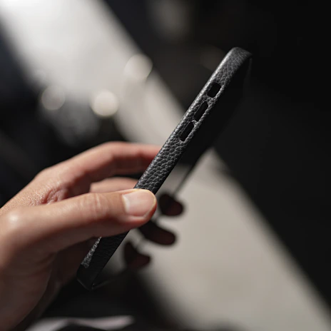 Lifestyle shot of a person holding an iPhone with the premium case in a vibrant color.