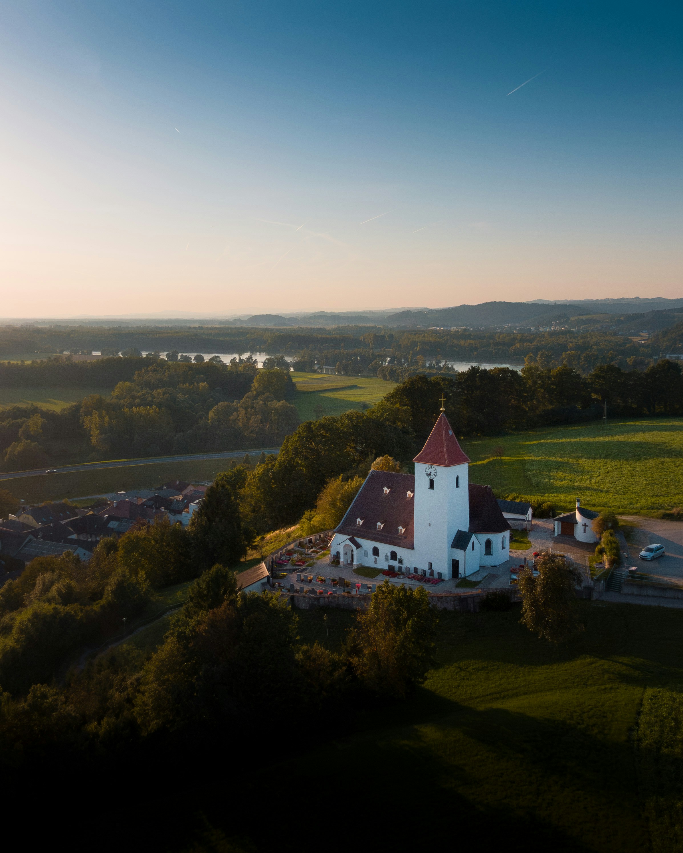 an aerial view of a church surrounded by trees