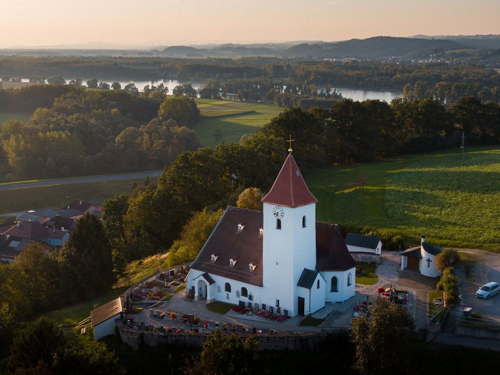 an aerial view of a church surrounded by trees