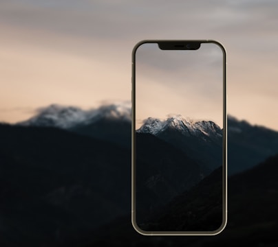 A smartphone displaying a clean, modern app interface with Swiss mountain scenery in the background.