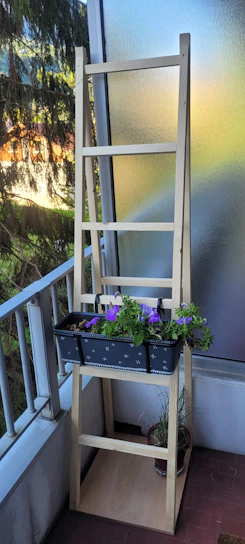 A sturdy, wobble-free shelving system holding plants and books on a sunny balcony.