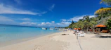 Scenic beach near Shiralea Resort with clear blue water and diving boats.