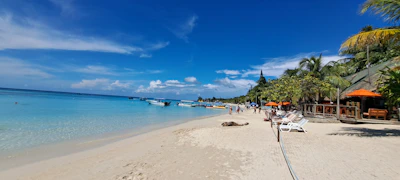 Scenic beach near Shiralea Resort with clear blue water and diving boats.