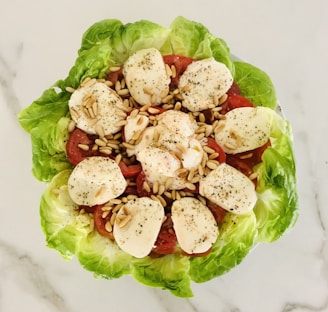A vibrant salad topped with slices of mozzarella cheese and vegetables.