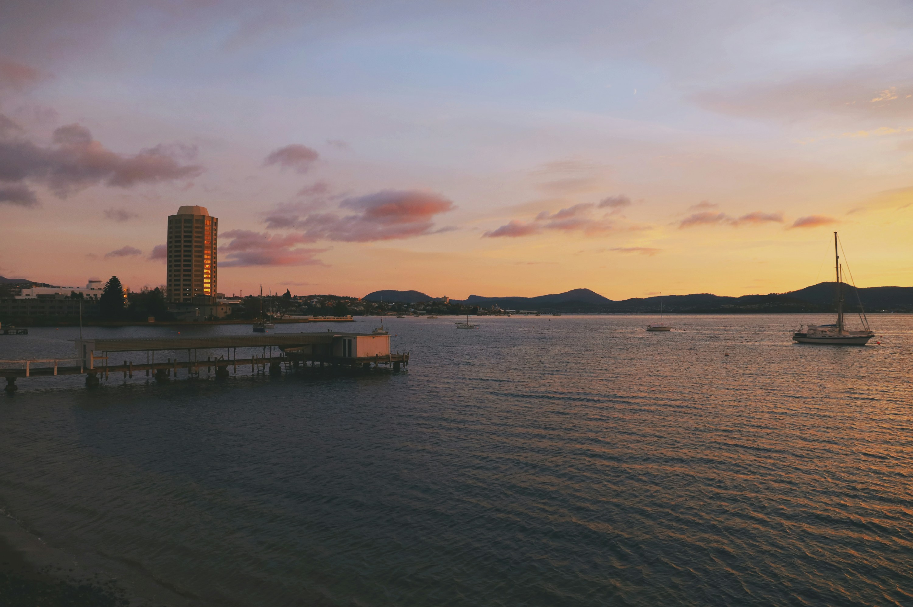 a boat is out on the water at sunset