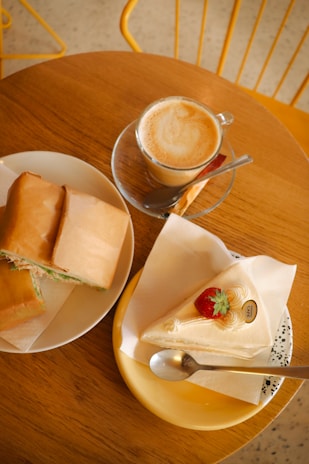 A rustic wooden table set with hearty sandwiches and steaming cups of coffee, inviting guests to sit and enjoy.