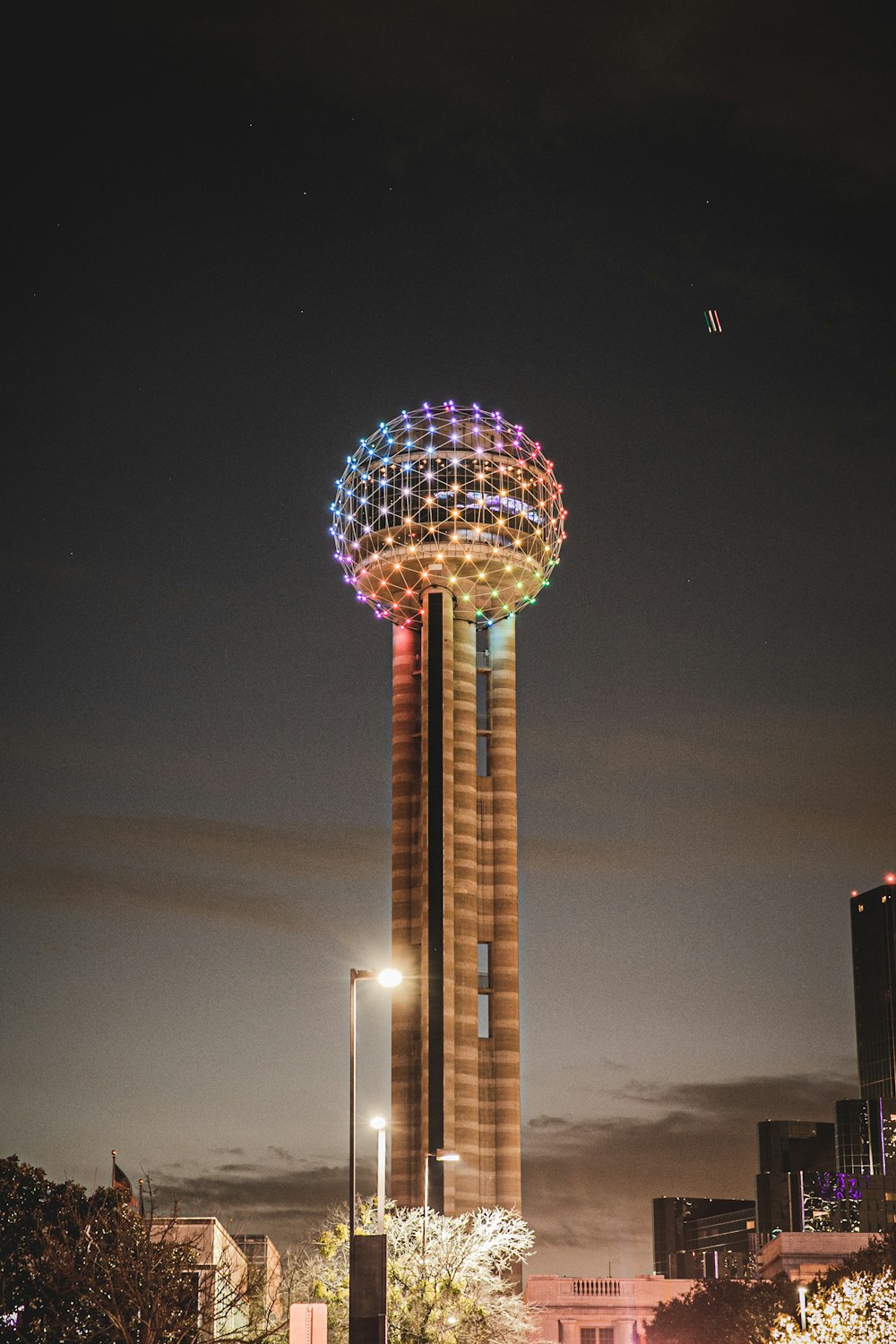 uma torre muito alta com uma luz colorida no topo