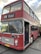 A vintage double-decker bus painted in a faded red color with white accents. The bus is labeled with the route number 025 and has 'Bristol' displayed on the sign above the windshield. The front features classic round headlights and a distinctive grille. The vehicle is parked and its door is open, showing a glimpse of the interior.