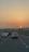 A sunset view over a highway with cars traveling in both directions.
