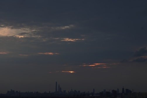 A sleek, cinematic still of the city skyline at dawn, hinting at supernatural elements.