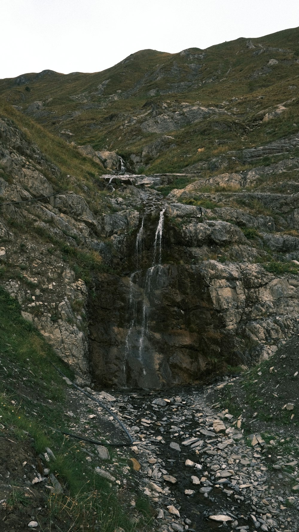 a mountain with a small waterfall in the middle of it