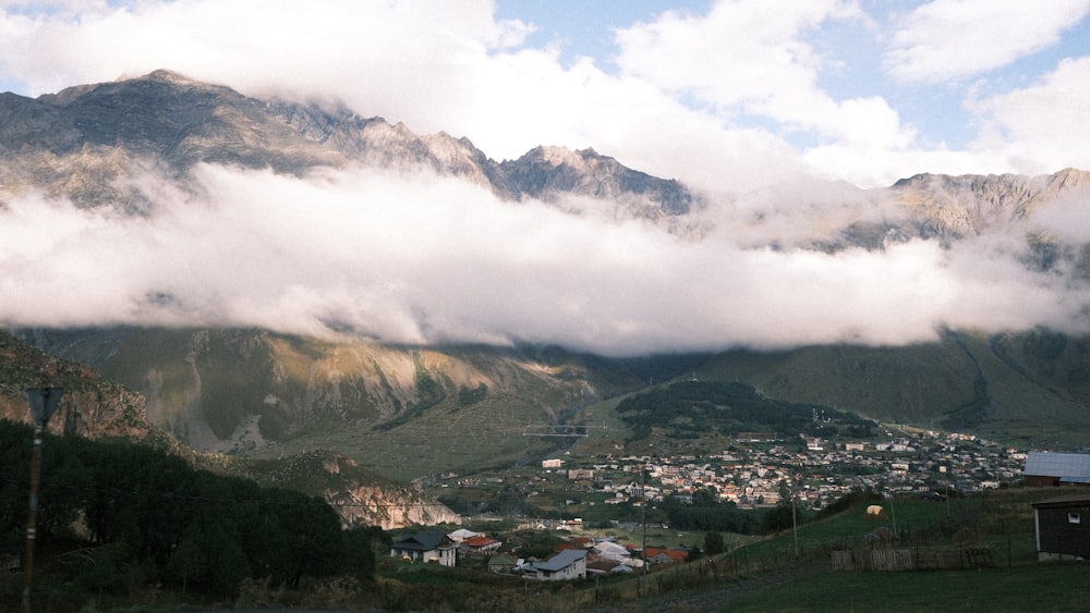 a scenic view of a town below a mountain range