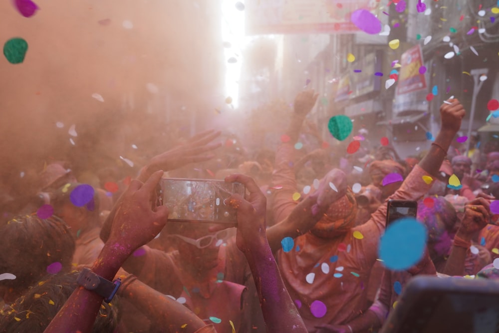 a crowd of people are throwing confetti on them