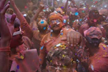 A lively festival celebration in West Bengal with dancers in bright costumes.