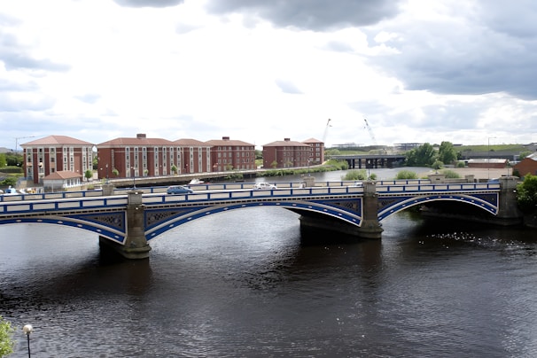 a bridge over a river with buildings in the background