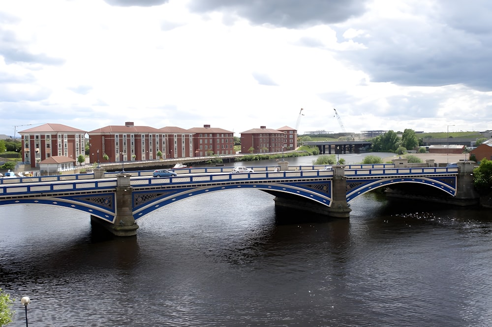a bridge over a river with buildings in the background