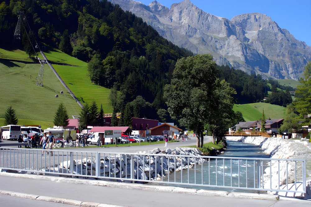 a scenic view of a small town with mountains in the background