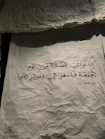 Close-up of traditional Arabic calligraphy art on textured parchment.