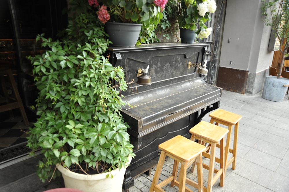 a piano sitting in front of a bunch of flowers
