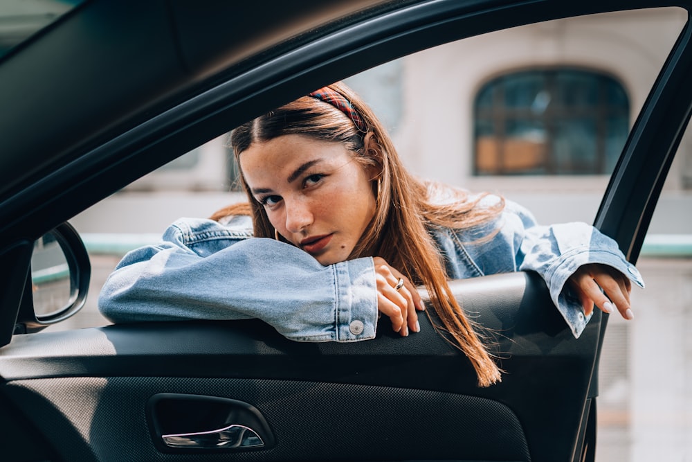 Una mujer inclinando la cabeza por la ventanilla de un coche