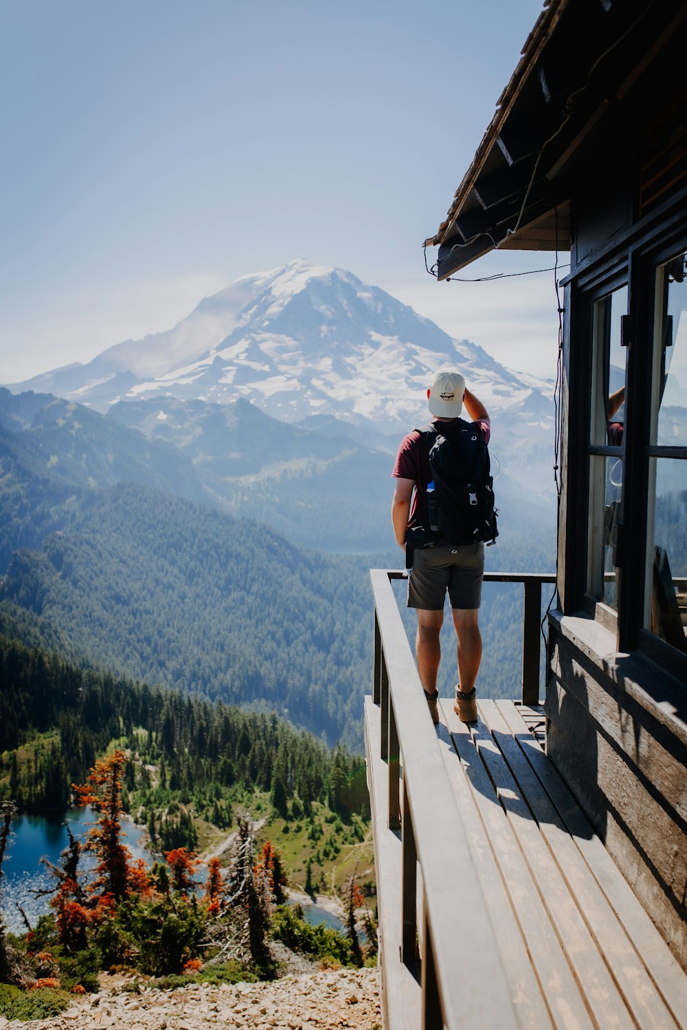 a man standing at the top of a mountain looking at a lake