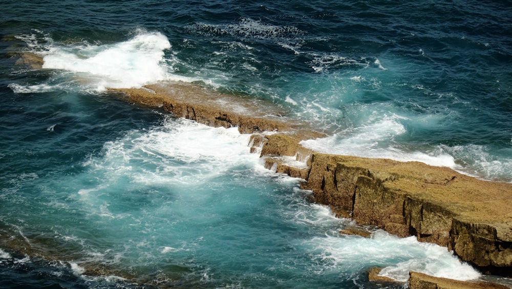 a large body of water next to a rocky cliff