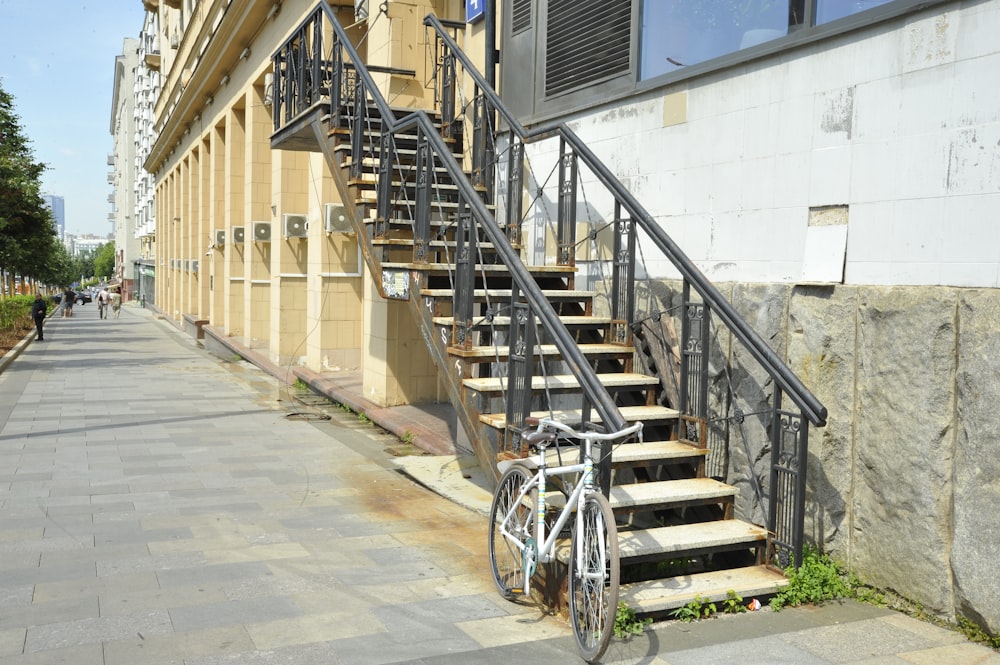 a bike parked on the side of a street next to a set of stairs