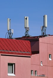 a red building with three antennas on top of it