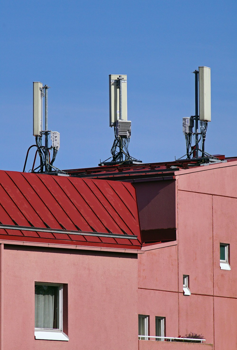 a red building with three antennas on top of it