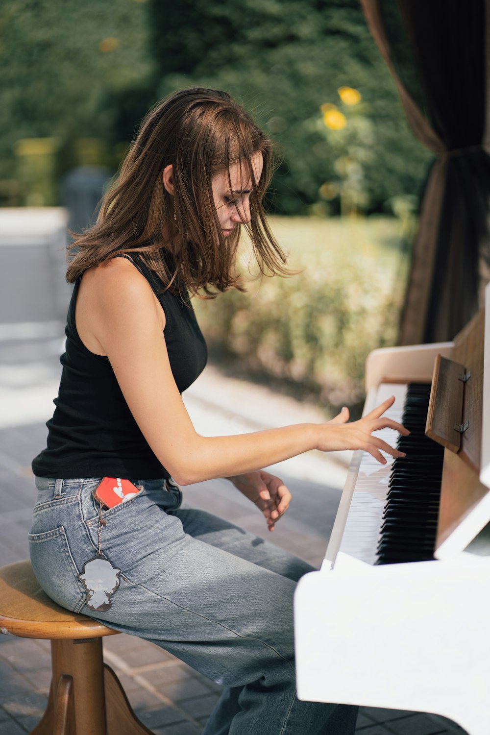 a woman sitting on a bench playing a piano